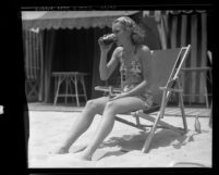 Actress Jane Wyman sitting in lounge chair on California beach, 1935