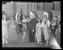 Delaware Indian Betti Haring puts headdress on California Attorney General Robert W. Kenny, 1943