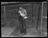 Boy holds a duck, Southern California, 1935