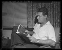 William A. Wheeler, investigator for the House Un-American Activities Committee, reading file on actress Lucille Ball