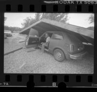 Dean Walters and car under collapsed carport after Chalfant earthquake, Calif., 1986