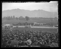 View from grand stands of crowd watching close finish at Santa Anita racetrack with mountains in background, Arcadia, 1935