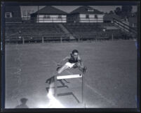 College athlete Leighton Dye jumping over a hurdle Los Angeles, 1920s