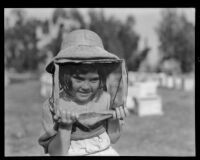 Young girl visits a bee farm, Los Angeles County, 1935