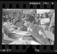 Howard Tsang and others competing in chow mein eating contest in Los Angeles' Chinatown, 1973