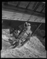 Men shoring up foundation of beach house threatened by tide, Newport Beach, 1934