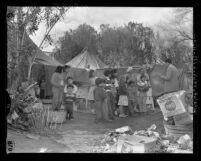 The Santos Lopez family, migratory farm workers talk with reporter in their tent camp in Nevada, 1959