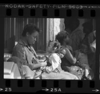 Rickie Gregory and daughter waiting along with other mothers for checkup at Watts Health Center in Los Angeles, Calif., 1985