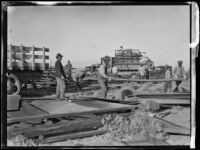 Workers move planks of wood at their worksite near the Los Angeles Aqueduct, Inyo County vicinity, [circa 1927]