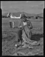 Jim Gould, hostler for Al. G. Barnes Circus, repairs a horse blanket, Baldwin Park, 1936