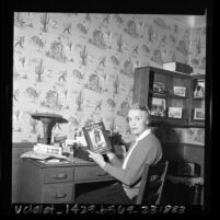 Writer Helen Addison Howard seated at desk with her book "Saga of Chief Joseph," 1966