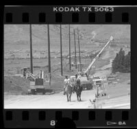 Horseback riders passing workers installing pipelines for development in Palmdale, Calif., 1987