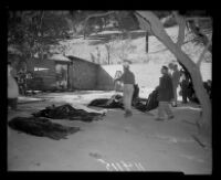 Police outside of the ruins of Fountain of the World headquarters look at bodies of the victims of the bombing. C. 1958