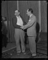 Kidnap victim William F. Gettle and an unidentified man shake hands after his rescue, possibly at the Los Angeles Hall of Justice, 1934