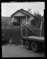 Workmen preparing house to be moved out of Chavez Ravine in Los Angeles, Calif