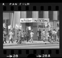 Pro-Nixon supporter picketing along side anti-war protesters outside Richard Nixon's Los Angeles campaign headquarters, 1972