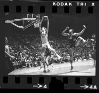 UCLA basketball player Bill Walton leaping for rebound in game vs Notre Dame, 1974