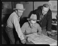 Sheriff R. S. Snedigar and his deputies, Louis H. Miller and Carl McNew, look over a map, Victorville, 1935