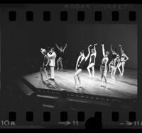 Clothing designer, Rudi Gernreich, onstage with models in swimsuits at Los Angeles Fashion Group's Man of the Year in 1968