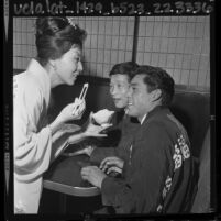 Kawafuku employee Chiyo Tota offering rice to boxers Fabian Esquivel and Hiroyuki Ebihara, 1964