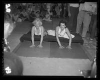 Marilyn Monroe and Jane Russell putting hand prints in cement at Chinese Theater, Hollywood (Los Angeles), 1953