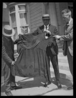 Three men hold a woman's garment, related to the investigation of the murder of Alberta Meadows by Clara Phillips, 1922-1923