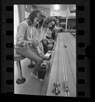 Boys and girls racing slot cars at racing center in Panorama City, Calif., 1964