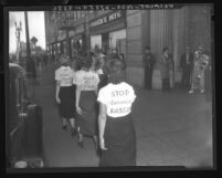 Female Young Communist League members with signs on back of their shirts picket Japanese Consulate in Los Angeles, Calif. 1937