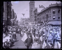 Street packed with spectators and marchers carrying American flags during Preparedness Day Parade, Los Angeles, 1916