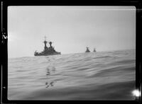 Port side view of three U.S. Navy battleships steaming through the water