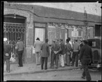 Men read notices posted on a building in Chinatown, Los Angeles, 1920-1939