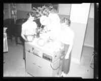 Sister Leo Paul demonstrating a new medical device to two school girls, St. Luke Hospital, Pasadena, 1953