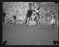 Trojan player defends a Utah receiver during the USC and Utah football game, Los Angeles, 1932