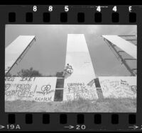 Jaybee Beswick painting over graffiti the on Hollywood Sign, Calif., 1986