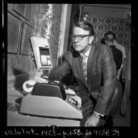 Robert Anderson, president of American Rockwell Corp., comparing large desk top calculator to a hand size one, 1970