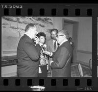 Henry Kissinger speaking with Peter Gold, Constance Austin, and Frank Ellsworth in Los Angeles, Calif., 1986