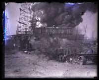 Workers digging tunnel in effort to cap the burning oil well behind them, Santa Fe Springs, 1929