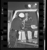 Los Angeles police officer and actor Kenneth Osmond talking with fellow officer in back of van, Los Angeles, Calif., 1980