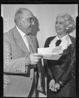 Margarete Clark and Frank A. Bouelle holding checks, Los Angeles, 1935