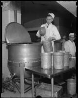 Cook in the Los Angeles County General Hospital kitchen stands beside a vat and pours liquid into a pot, Los Angeles, [1934]