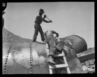 Workers make repairs on a damaged section of the Los Angeles Aqueduct in No-Name Canyon, Inyo County vicinity, [about 1927]