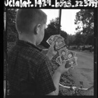 Boy holding baseball cards, one set with baseball players; second set with pictures of The Beatles, 1964