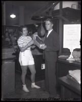 Boxing Champion Billie Bachelis replaces a punching bag at a May Company demonstration, Los Angeles, 1931