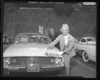 Actress Ginger Rogers pastes Nixon-Lodge sticker on automobile as she talks to actor Cesar Romero, Calif., 1960