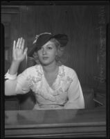 Actress Grace Bradley being sworn in on a witness stand, Los Angeles, 1935