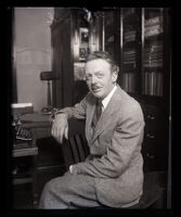 Sculptor Gilbert Riswold sits at a desk in an office, Los Angeles, 1930