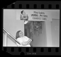 Actress Zelda Rubenstein posing with L.A. CARES "Play Safely" AIDS poster in Los Angeles, Calif., 1985