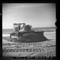 Tractor sieving sand along shore at Redondo Beach, Calif., 1975