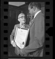 Tom Bradley presenting diploma to comedian George Burns in Los Angeles, Calif., 1977