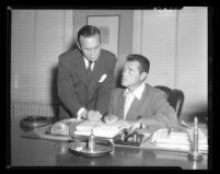 Tom Neal (right) and Attorney Milton golden discuss fight between the former and Franchot Tone, which left the latter hospitalized, 1951